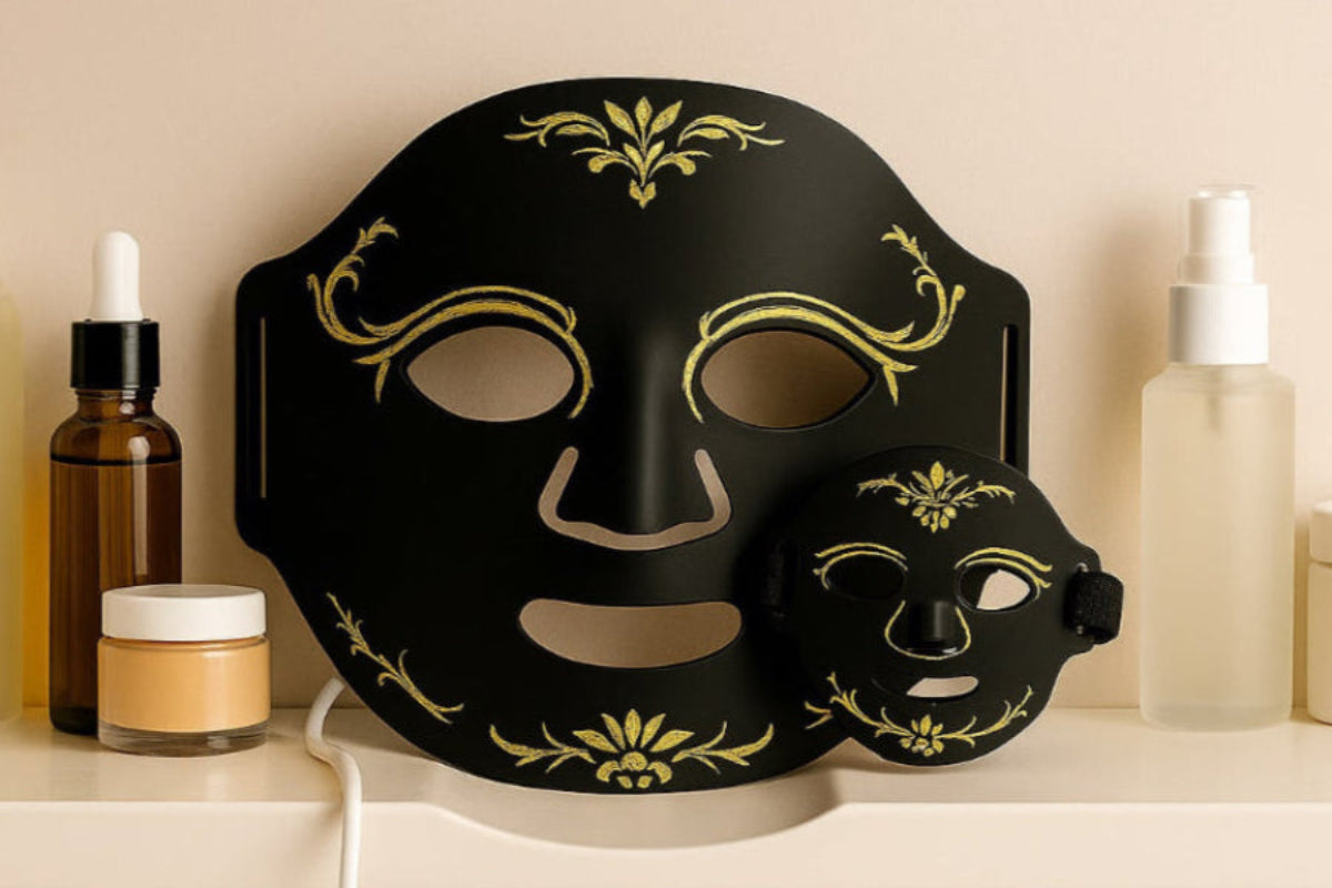 Black decorative mask with gold patterns on a shelf with skincare products.