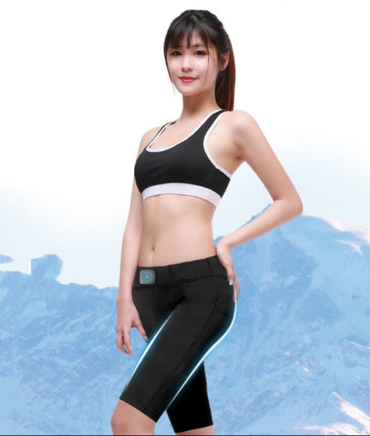 Woman wearing a black sports bra and leggings with a blue mountain background