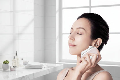Woman using Hot & Cold LED Microcurrent Beauty Device on her face 