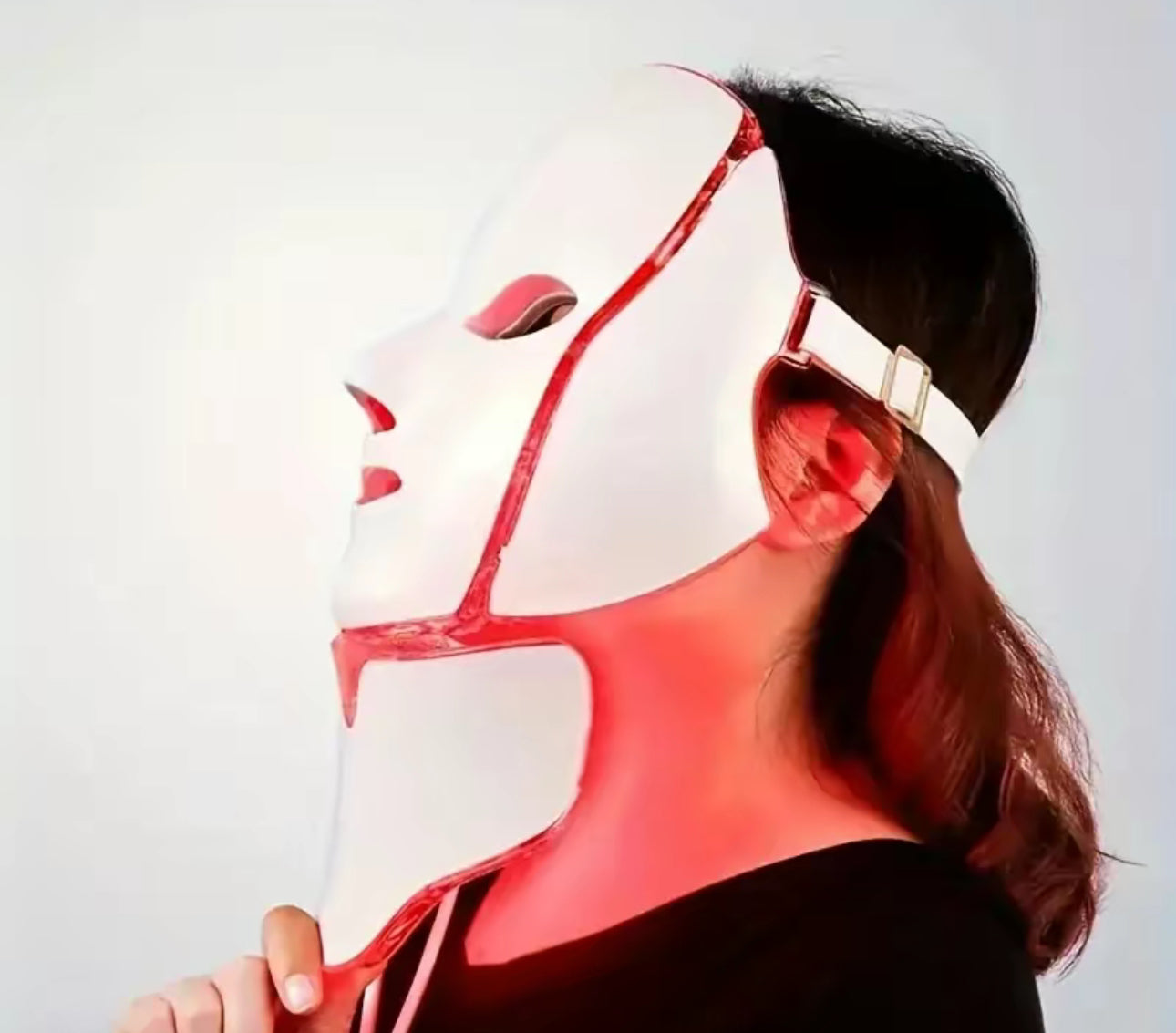 Person wearing a white and red mask with a plain background