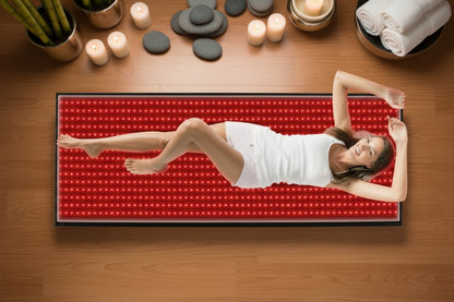 Woman lying on a red LED mat with a white background