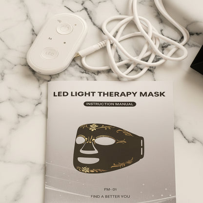 LED light therapy mask with instruction manual and control device on a beige background