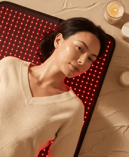 Woman lying on a LED therapy mat with a warm ambiance