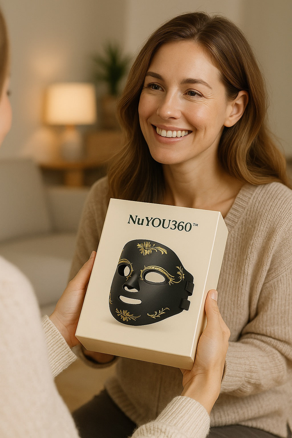 Woman receiving a NuYOU360 mask box from another person in a cozy indoor setting.