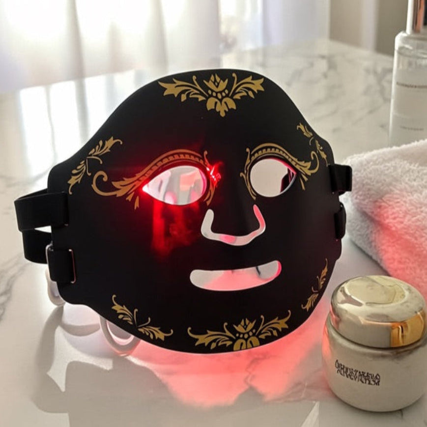 Facial mask with LED lights on a marble surface with skincare products.