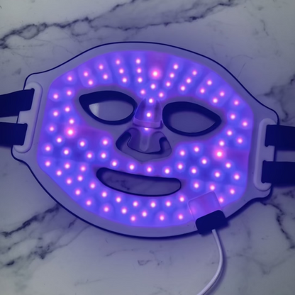 LED face mask on a white fabric background