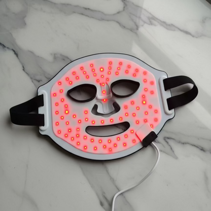 LED face mask with red lights on a light gray background