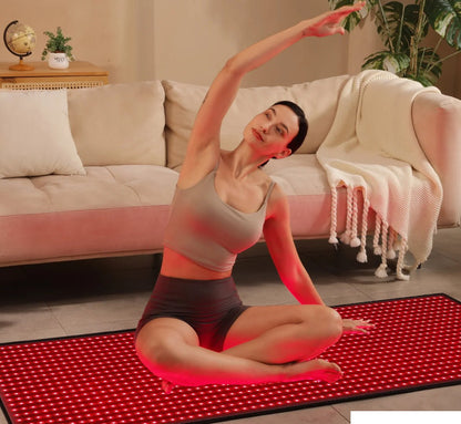 Woman practicing yoga on a red mat in a living room.