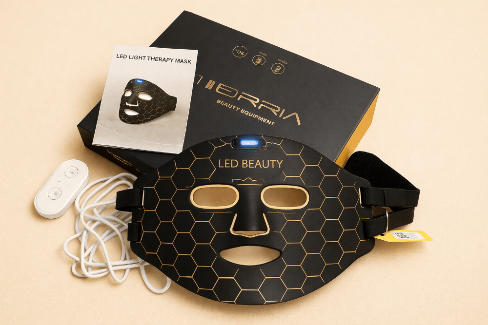 LED light therapy mask with packaging and remote control on a beige background