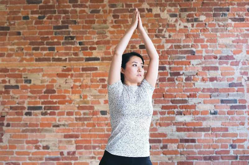 young-woman-against-exposed-brick-doing-yoga