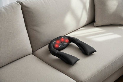 Black neck and shoulder massager with red lights on a white background