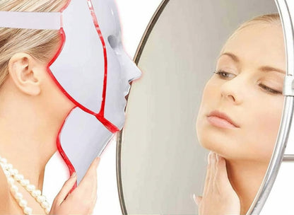 Woman using a LED face mask with a mirror reflection.